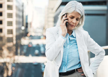 This isnt the news I wanted to hear. a mature businesswoman standing alone outside and using her...