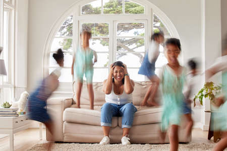Young single mother having a mental breakdown while her naughty children plays around her in the...