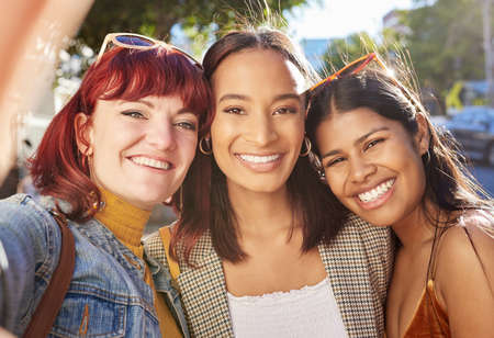 Selfies out on the town. Cropped portrait of three attractive young girlfriends taking selfies while out on the town.の写真素材