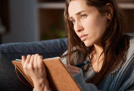 Getting it all out. an anxious young woman writing in her journal.