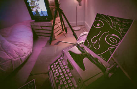 Still life of a dark room with a typewriter and strange disturbing images in a bedroom. Still life...