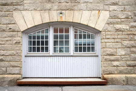 Oldwindow. Architecture of an old window in a brick wall. Facade of vintage white or classic windows...