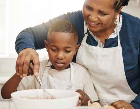 Sweet boy, sweet cakes. a grandmother baking with her grandson at home.の写真素材