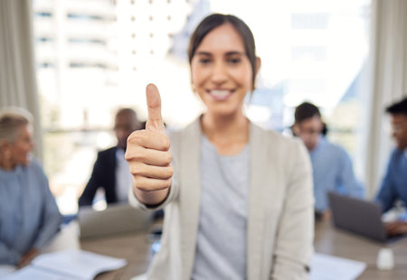 May all your opportunities lead to success. Closeup shot of a young businesswoman showing thumbs up in an office with her colleagues in the background.の写真素材