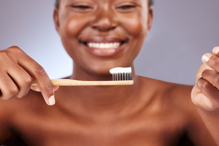 Keep a healthy smile. Studio shot of a beautiful young woman brushing her teeth.の写真素材