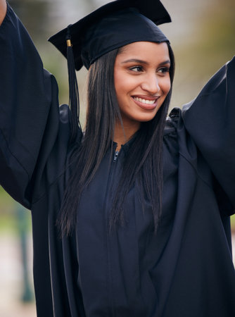 Graduated and loving it. a young woman cheering on graduation day.の写真素材