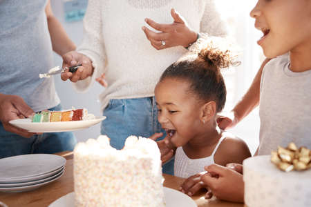 Wisdom doesnt necessarily come with age. a family preparing to eat a cake at a birthday party at home.の写真素材