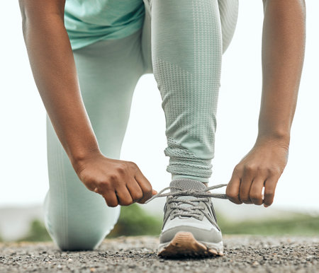 Lets do this. an unrecognizable person tying their shoelaces before a run.
