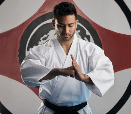 Showing respect to his opponent. a handsome young martial artist practicing karate in his dojo.