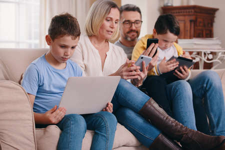 Everyones happy. a young family bonding while using their electronic devices together at home.
