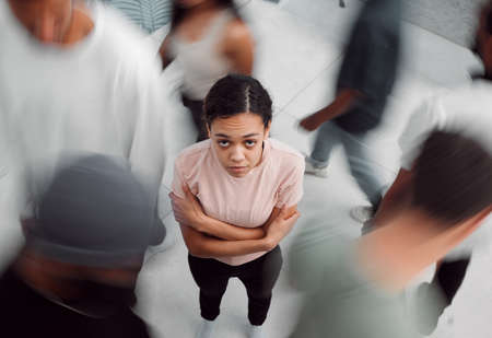 a young woman experiencing mental illness while being surrounded by people inside.の写真素材