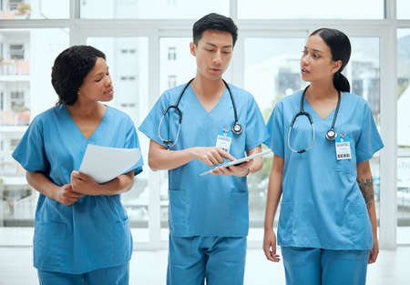 Walk and talk guys. a group of medical practitioners having a discussion in a hospital.