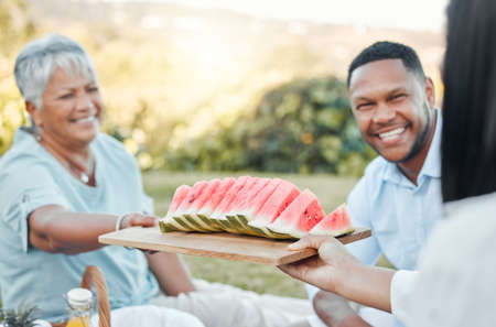 Pass along the value of empathy to our children. a father and son enjoying watermelon at a picnic.の写真素材