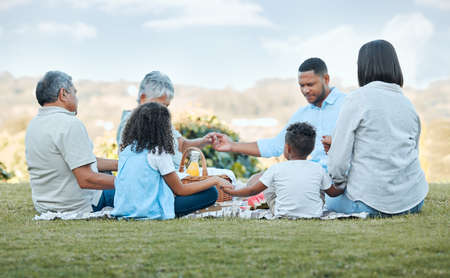Being a family means you are a part of something. family praying outside.の写真素材