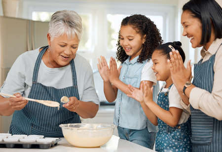 Gran is the expert at baking. a multi-generational family baking together at home.の写真素材