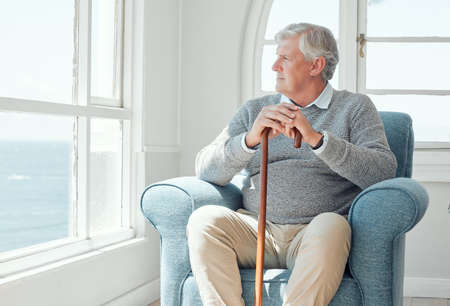 You never stop missng those youve lost. an elderly man enjoying the view from his window.の写真素材