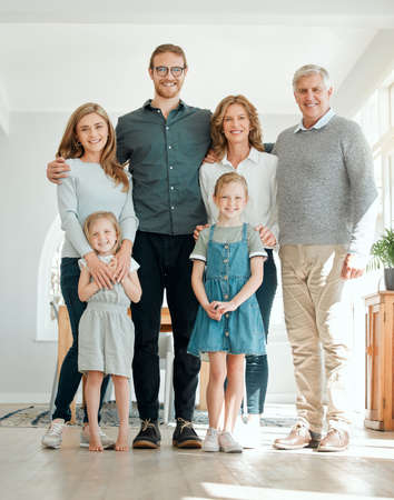 Meet our happy family. Full length shot of a family standing together during a relaxing day at home.
