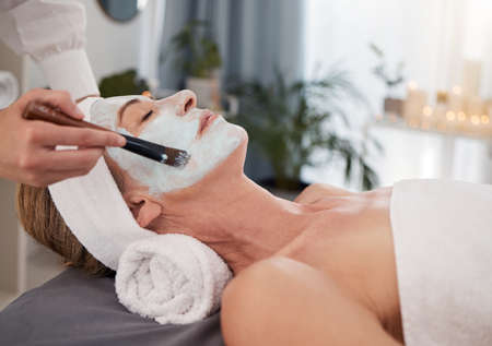 This is what skin renewal is all about. a mature woman enjoying a relaxing facial at a spa.の写真素材
