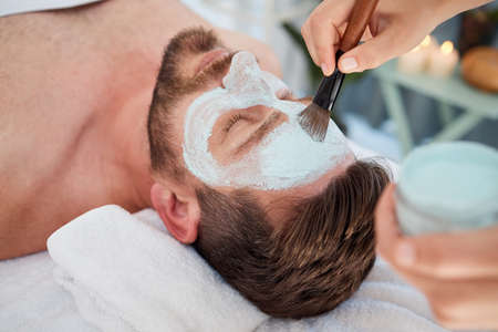 Take a deep breath and just enjoy life. a young man enjoying a relaxing facial at a spa.の写真素材