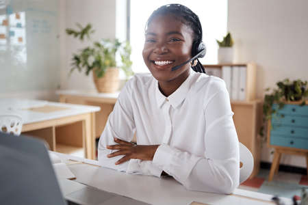 a young business woman using a headset and laptop in a modern office.