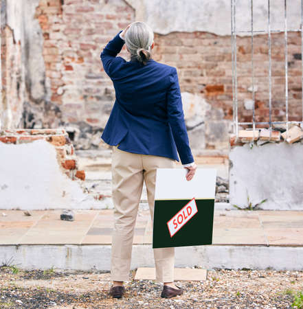 a real estate standing outside a burned down property.
