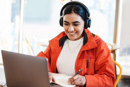a young female student using a laptop while studying at college.