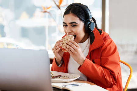 a young female student using a laptop while studying at college.