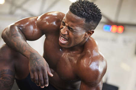 a muscular young man sweating while exercising in a gym.