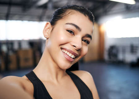 Everything you do is everything youll become. Portrait of a fit young woman taking selfies at the gym.の写真素材