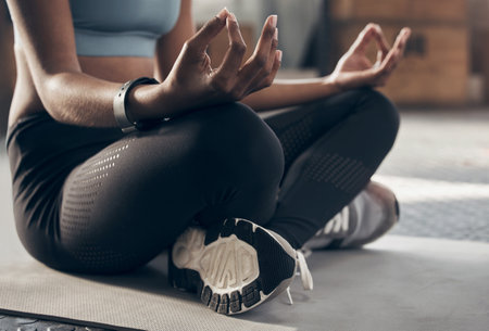 Make your day more zen. Closeup shot of an unrecognisable woman meditating in a gym.の写真素材
