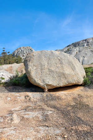 Big rocks on a mountain with a blue sky background and copy space. Large stones with beautiful rough texture details on a sunny day. Closeup outdoor nature landscape of boulders on a rocky hillの写真素材