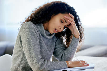 The secret of success is to do the common things. a young woman looking stressed while working from...