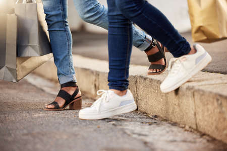 The super sale starts today. two unrecognisable woman walking through the city during a shopping...