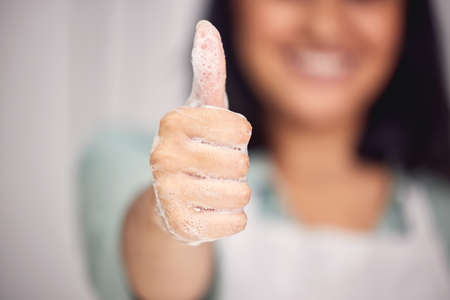 Yes to lots of soap. a woman showing thumbs up with her soapy hands.の写真素材