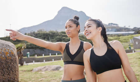 The best competition is healthy competition. a young women pointing while going for a run with her...