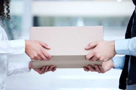 We cater to all your logistical needs. Closeup shot of an unrecognisable man making a delivery to a customer.の写真素材