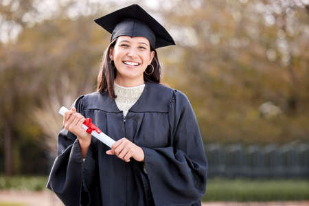I just cant stop smiling today. Portrait of a young woman holding her diploma on graduation day.の写真素材