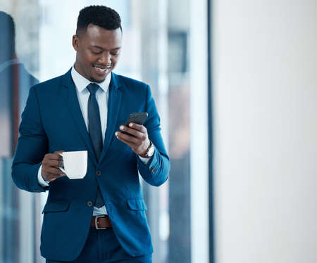 Another successful day downloaded. a young businessman using a smartphone in a modern office.