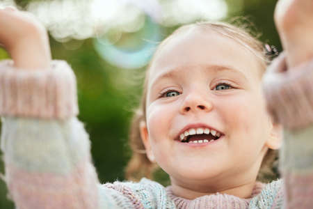 It doesnt take much to entertain a child. an adorable little girl playing outside.