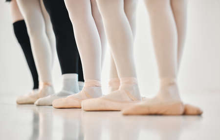 Light on our feet. a group of unrecognisable ballet dancers practicing their routine in a dance studio.の写真素材