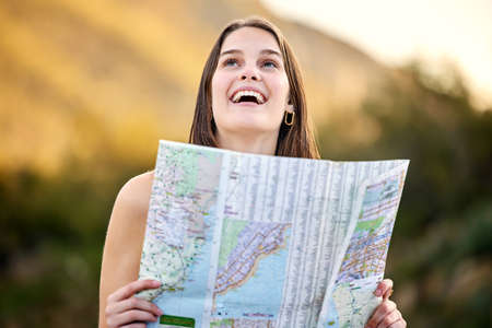 I love the beautiful city. a young woman holding a map while out exploring.