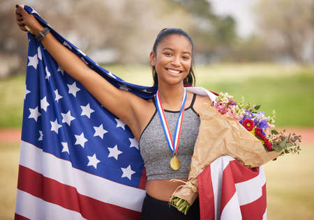 The winners circle. Cropped portrait of an attractive young female athlete celebrating a victory for her country.の写真素材