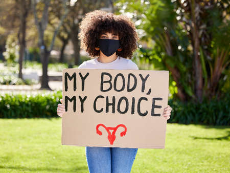 One has not only a legal but a moral responsibility. a unrecognizable woman protesting outside in the park.の写真素材