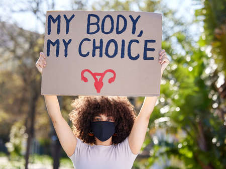 It is absolutely essential. a unrecognizable woman protesting outside in the park.の写真素材