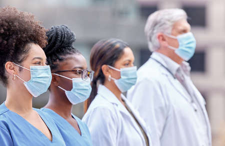 Were on the frontlines so you dont have to be. a group of doctors standing together in the city.の写真素材