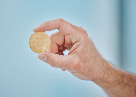 The future is in bitcoin. an unrecognisable businessman holding a bitcoin in the office.