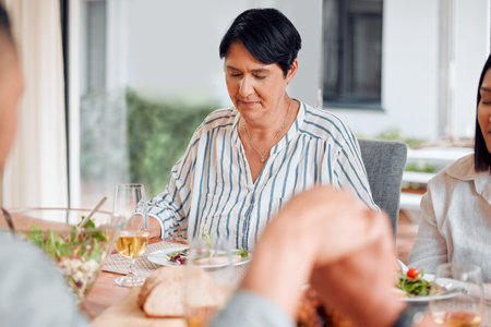 Lets say a prayer. a family having lunch together at home.の写真素材