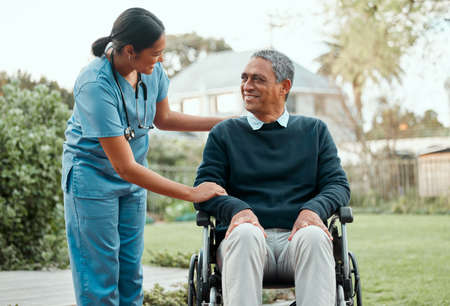 Head full of clouds on a sunny day. a young nurse caring for an older man in a wheelchair.の写真素材
