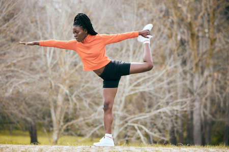 Finding my balance. Full length shot of an attractive young woman standing and stretching before...