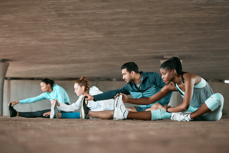 Excited to begin our fitness journey. a group of friends stretching together before a workout.の写真素材
